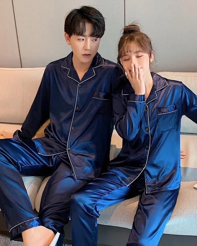Two people relaxing in navy satin pyjama sets